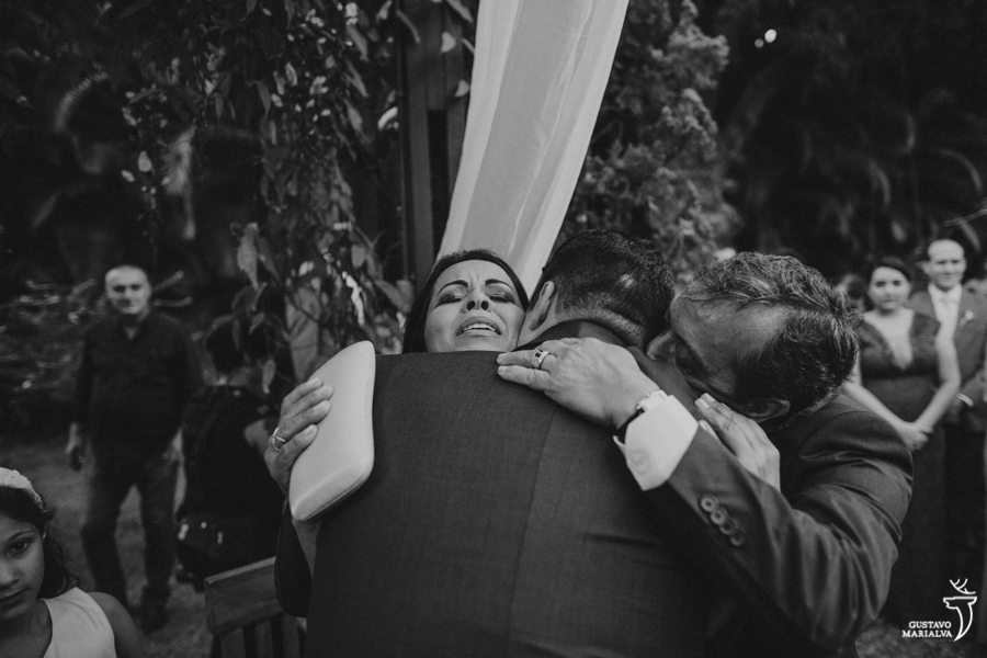 pais emocionados abraçando o noivo