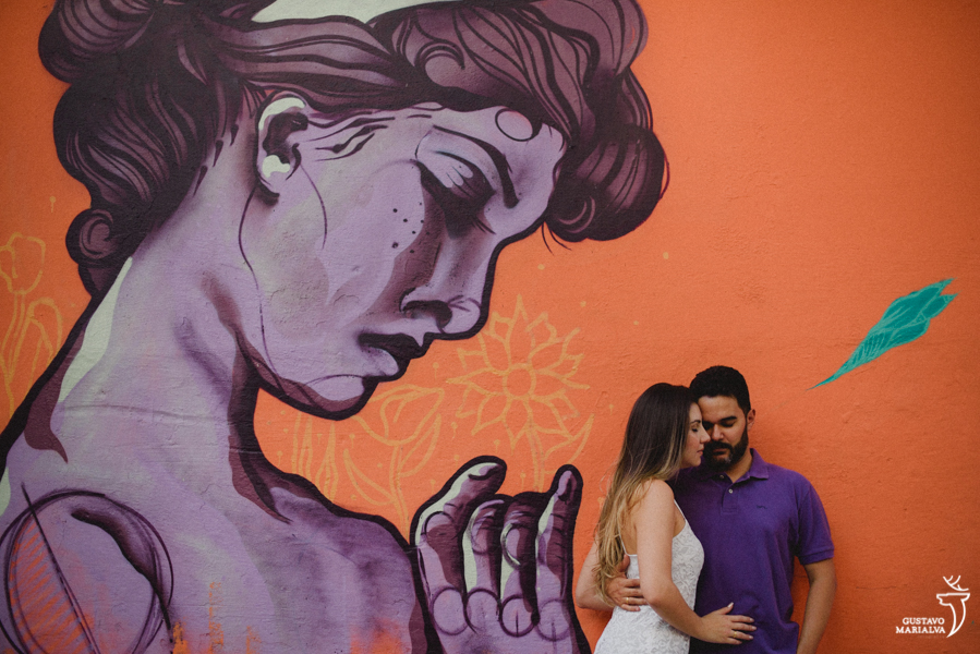 noivos namorando em frente a um grafite