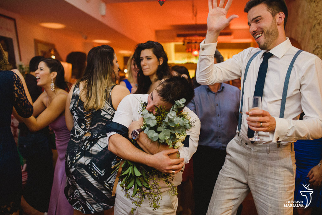 Amigo agarrando o buquê na festa de casamento