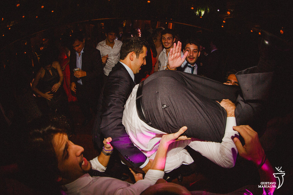 noivo sendo carregado na festa de casamento