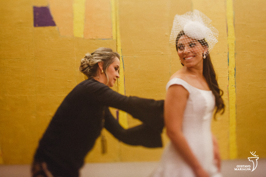 tia da noiva fechando o vestido de casamento
