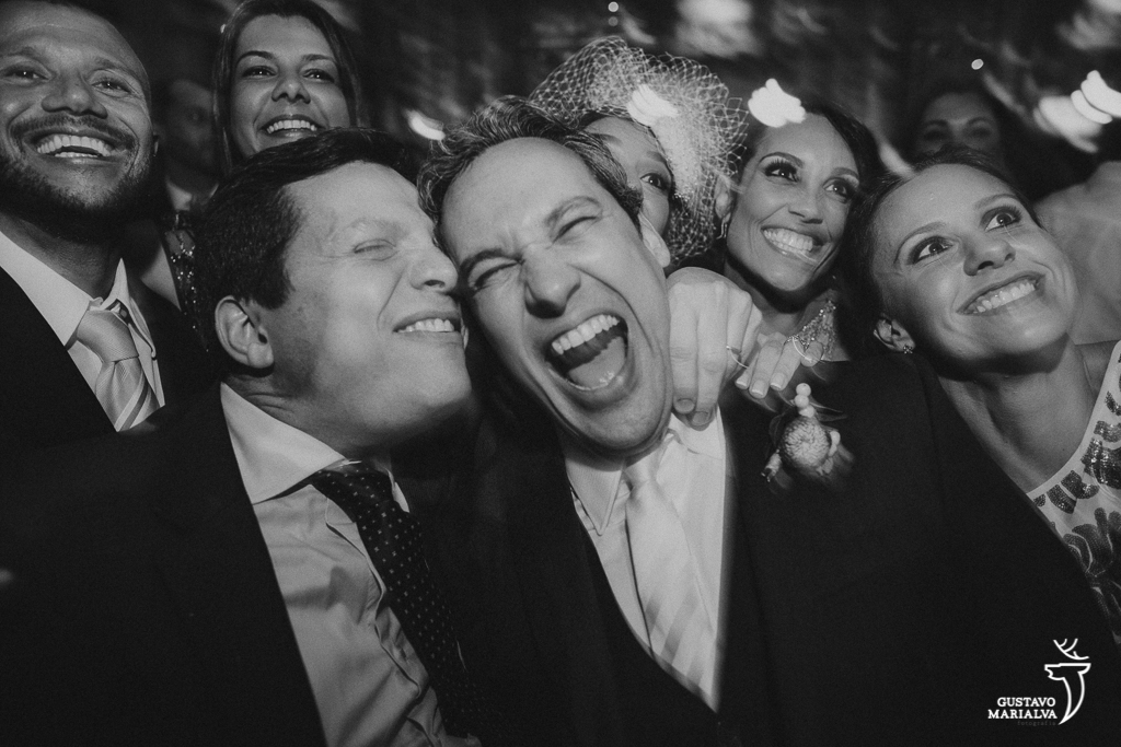 noivos e convidados sorrindo durante a festa de casamento