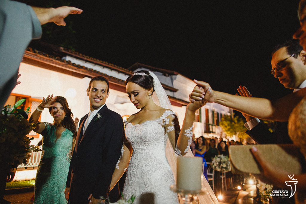 noiva segurando a mão da mãe na cerimônia de casamento