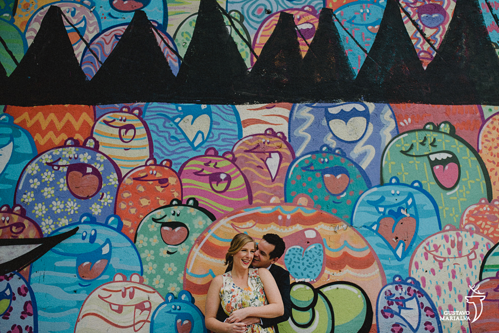 noivos posando em frente a grafite durante book de casal