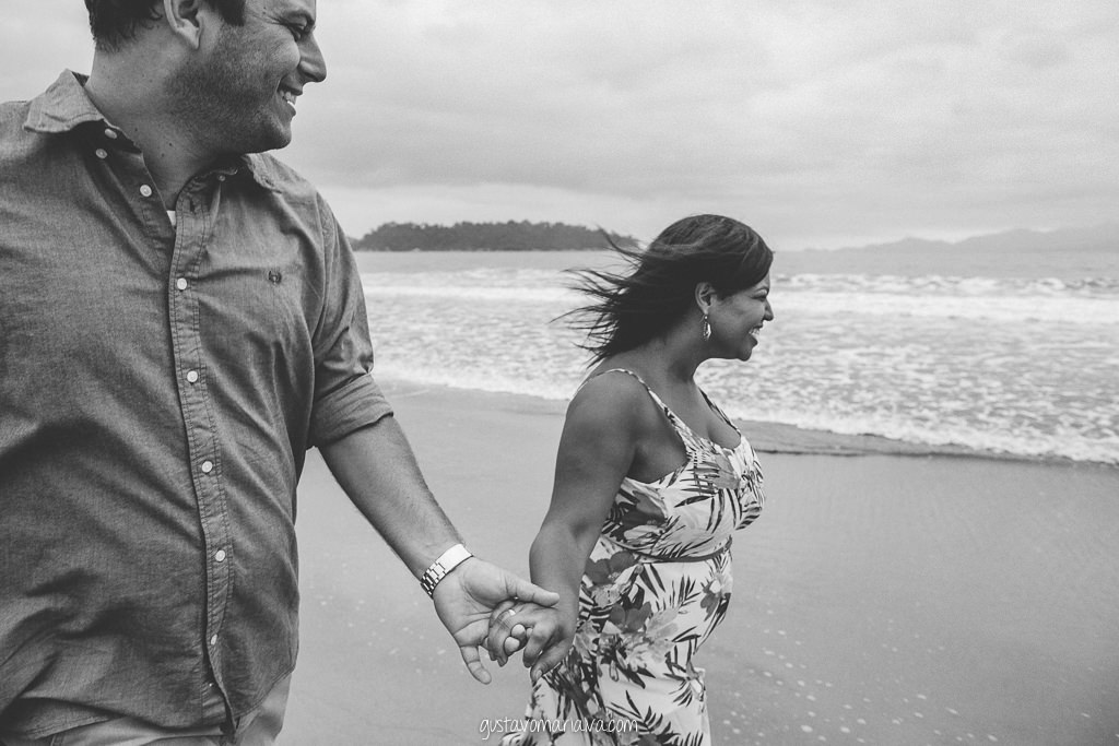 casal correndo na praia durante book de casal