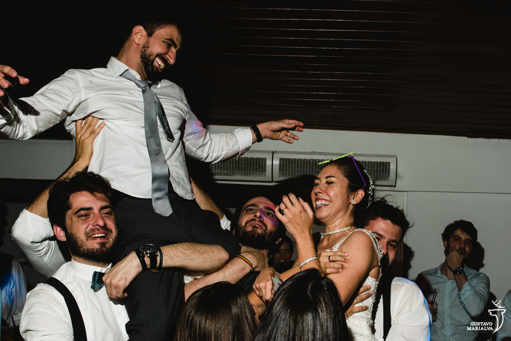 noivos sendo jogados para o alto na festa de casamento