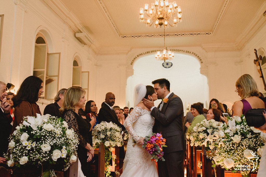 noivos se beijando na saída da cerimônia de casamento