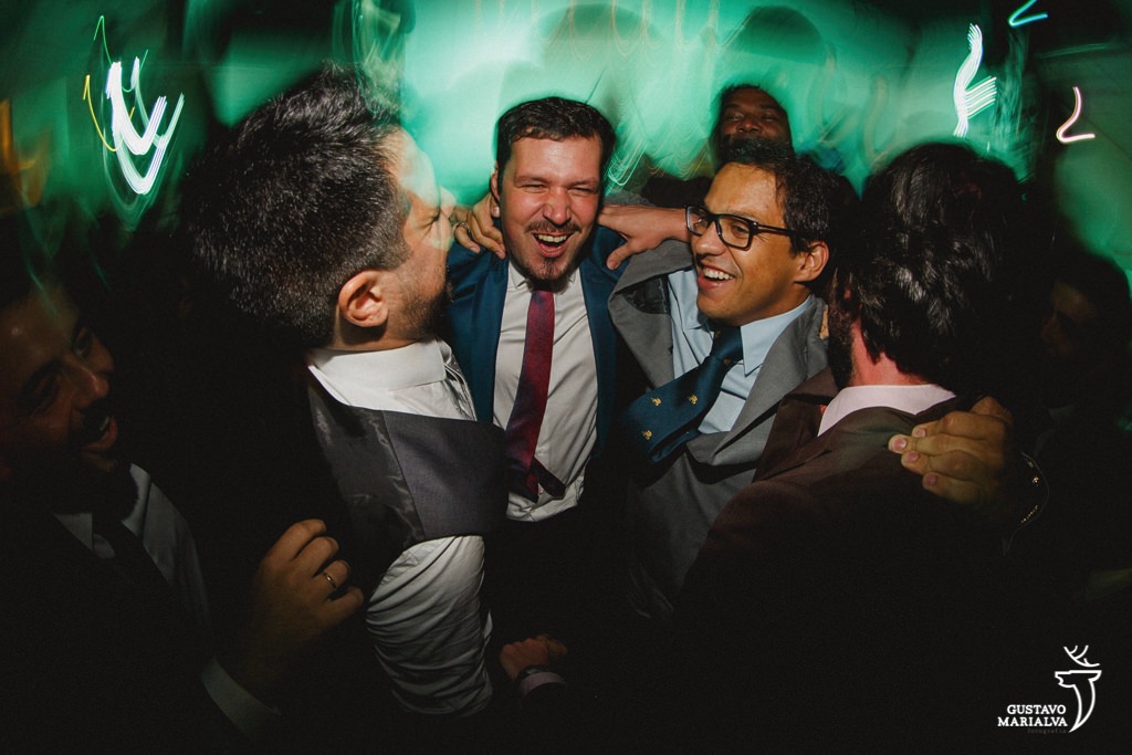 noivo e amigos pulando na festa de casamento