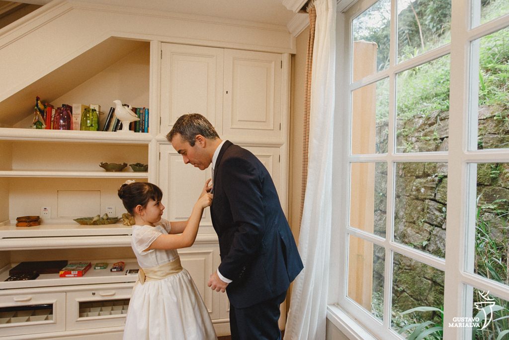 filha do noivo arrumando a gravata durante making of de casamento