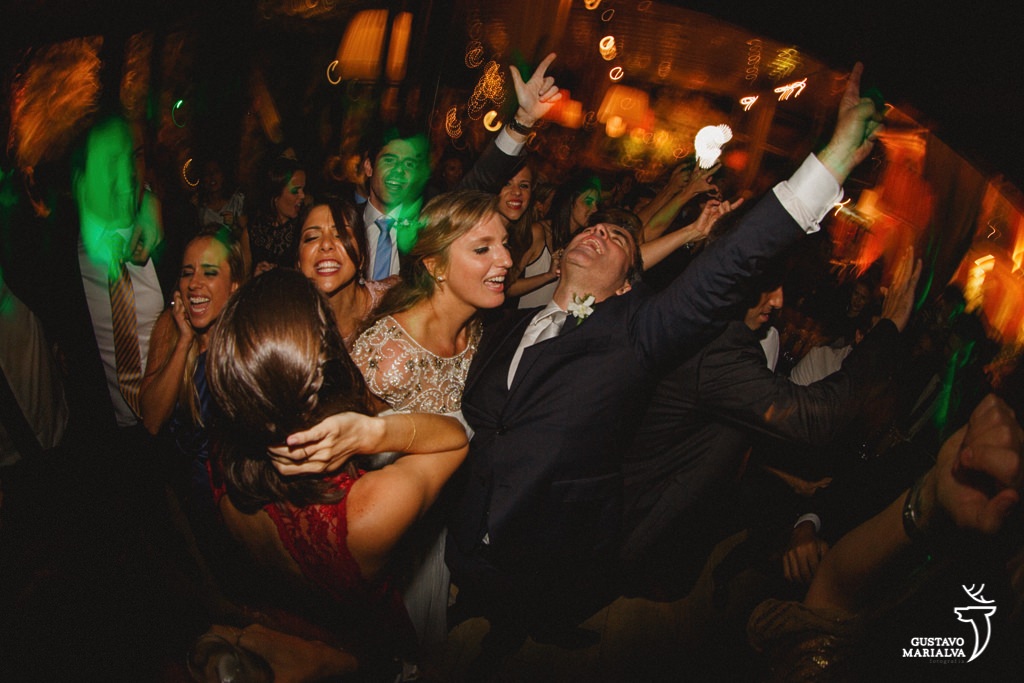 noivos e convidados vibrando na festa de casamento