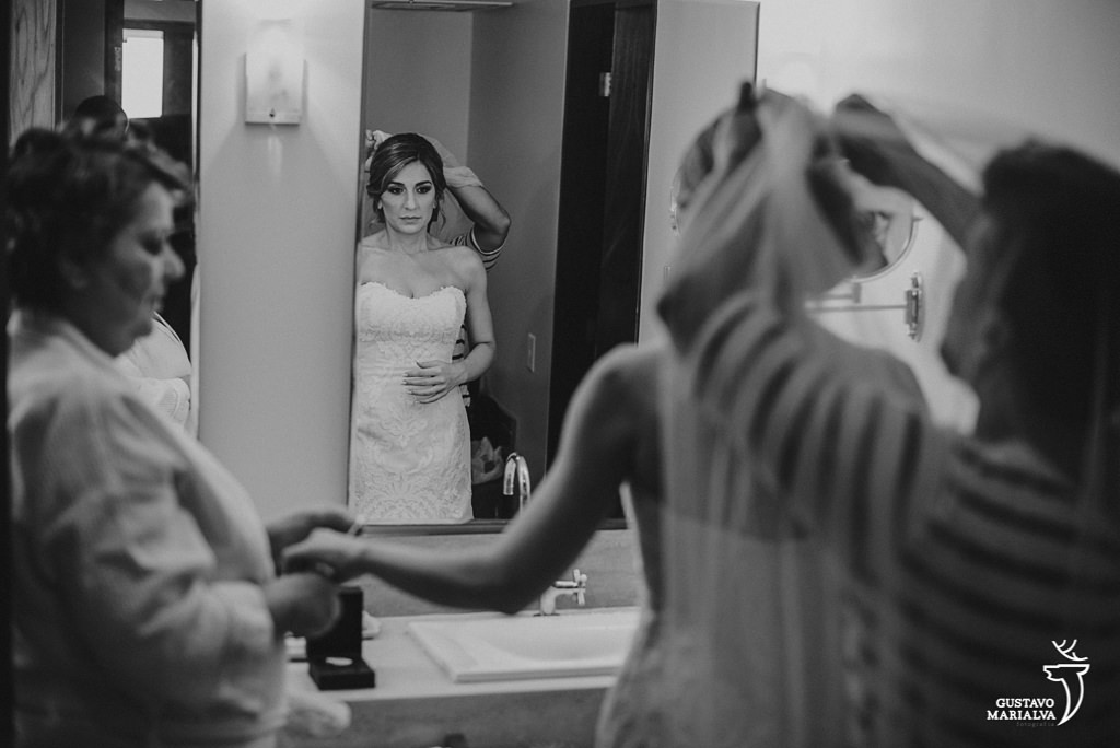 noiva colocando o véu e dando as mãos para a mãe durante o making of do casamento