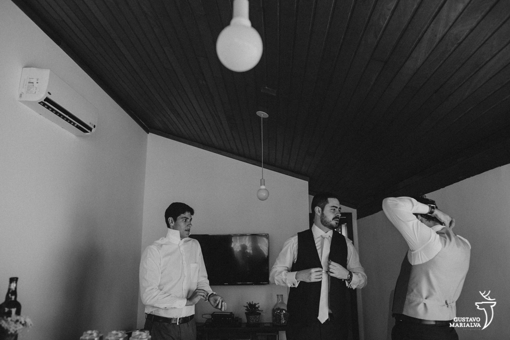 noivo colocando a gravata durante o making of do casamento
