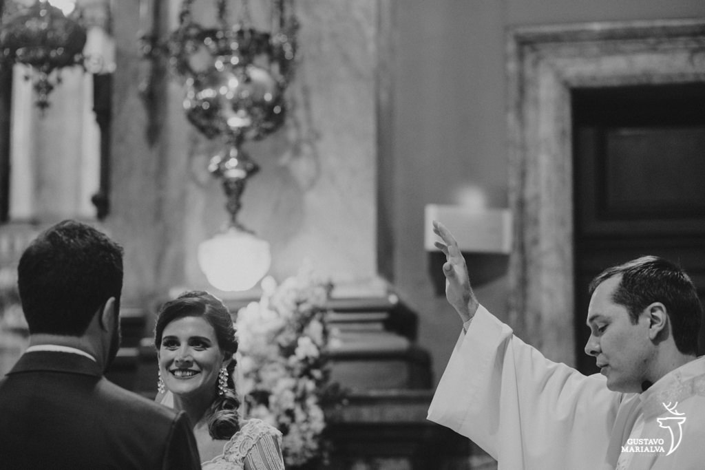padre abençoando os noivos na cerimônia de casaemnto