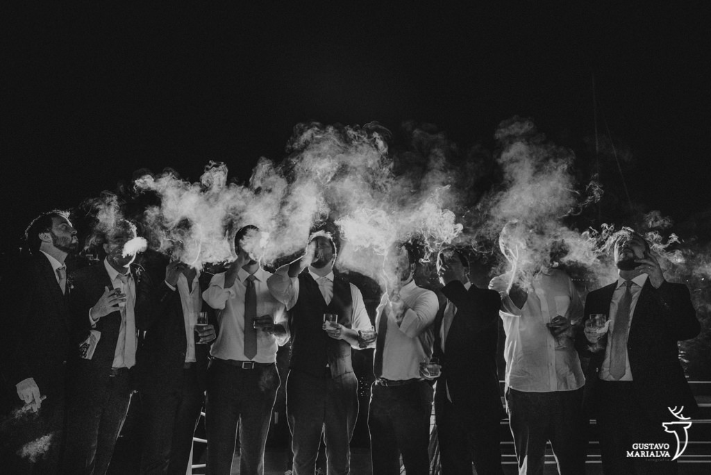 noivo e amigos fumando charuto na festa de casamento
