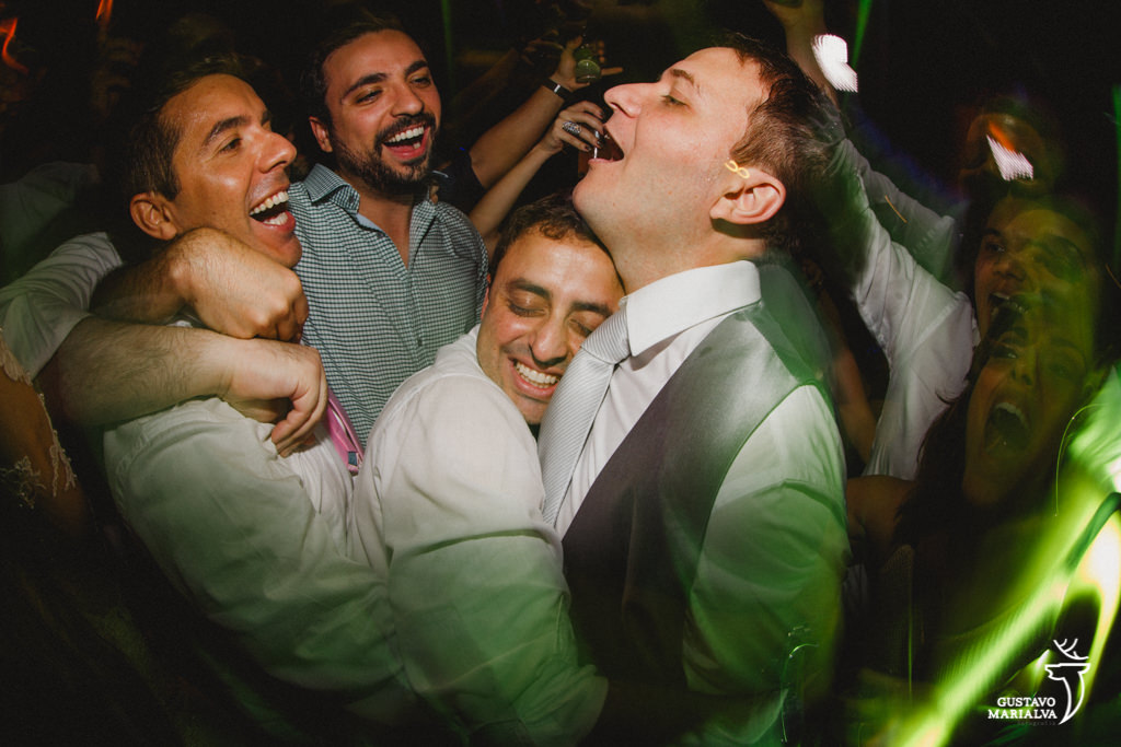 amigos abraçando o noivo na festa de casamento