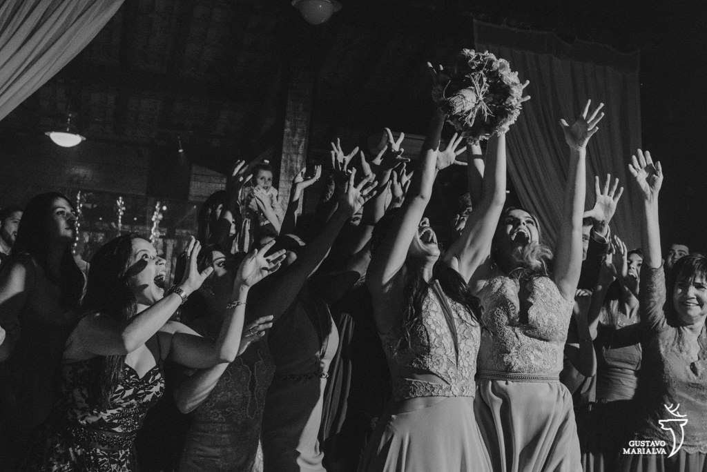 amigas disputando o buquê na festa de casamento