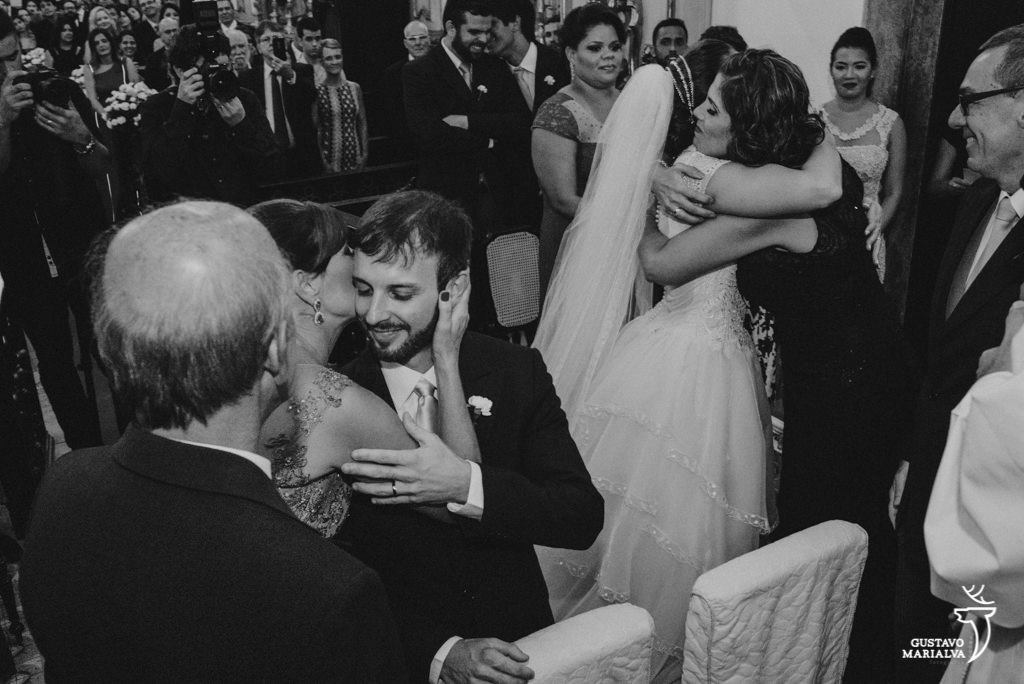 mães abraçando os noivos durante a cerimônia de casamento