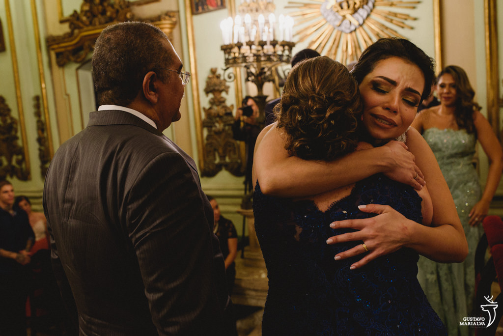 noiva emocionada abraçando a mãe do noivo na cerimônia do casamento