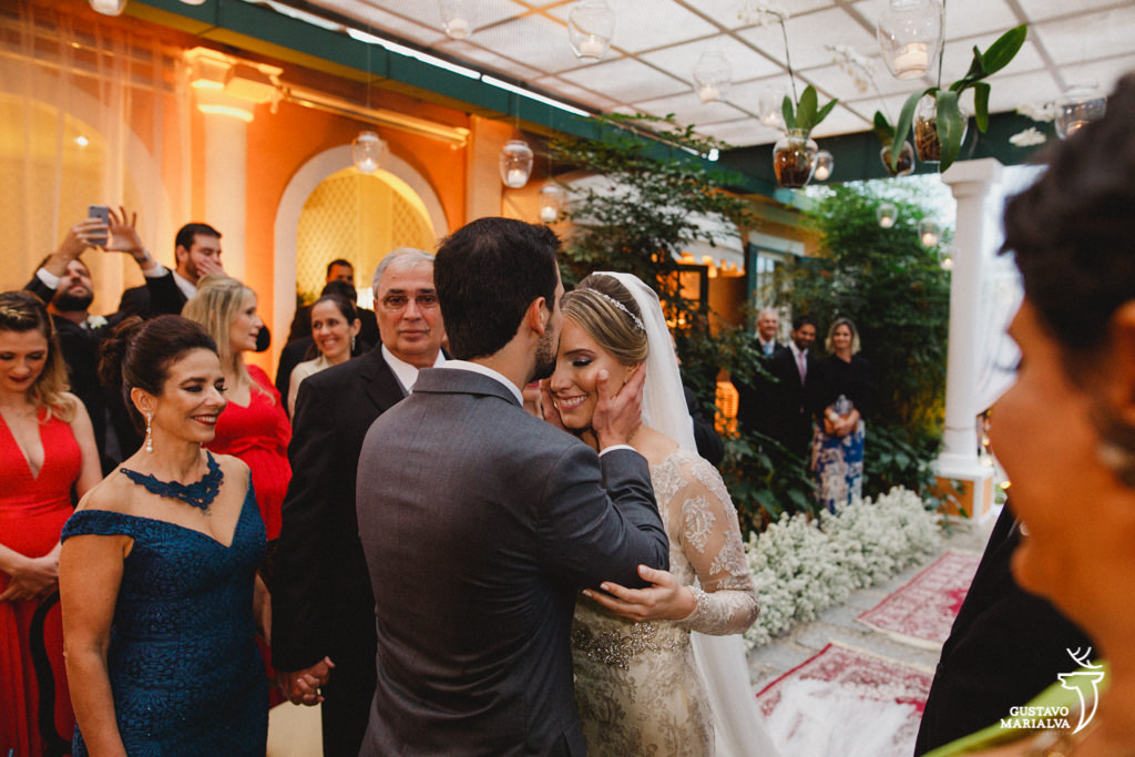 noivo beijando a testa da noiva durante a cerimônia de casamento