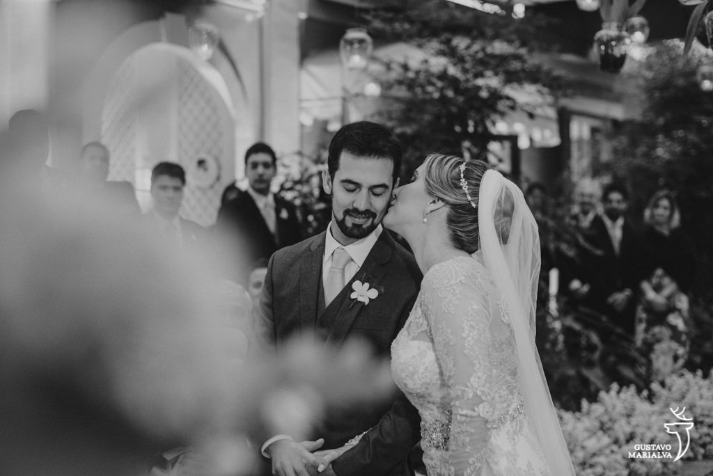 noiva beijando o noivo durante a cerimônia de casamento