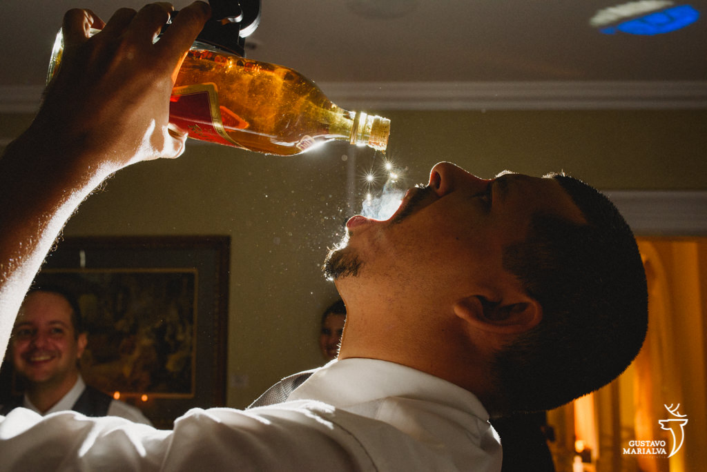 convidado bebendo whisky da garrafa
