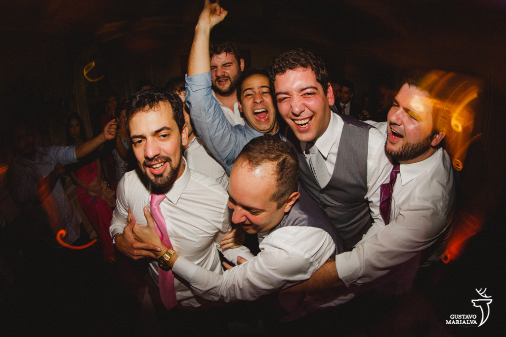 amigos agarrando o noivo na festa de casamento