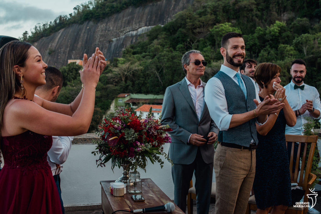 noivo e convidados aplaudindo a entrada da noiva na cerimônia de casamento