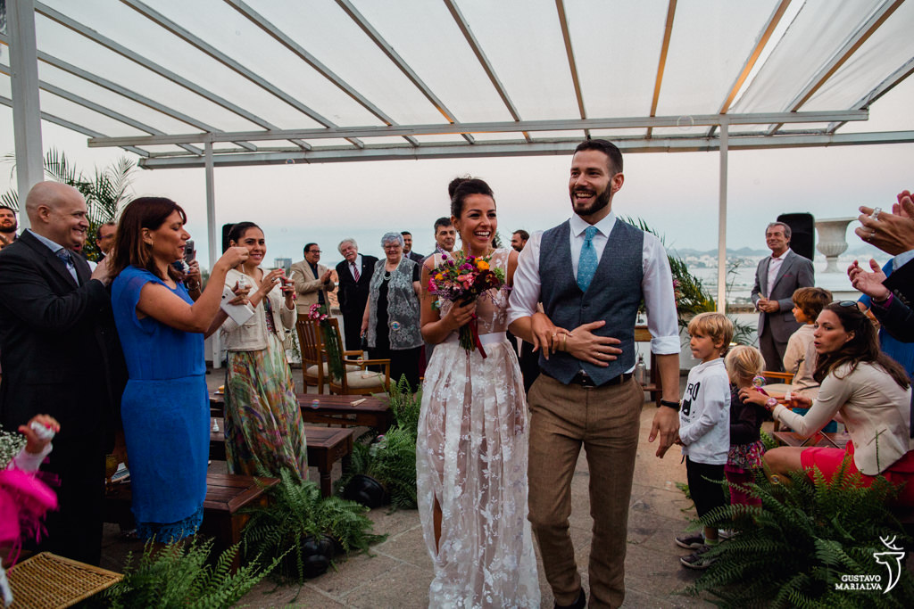 noivos sorrindo na saída da cerimônia de casamento