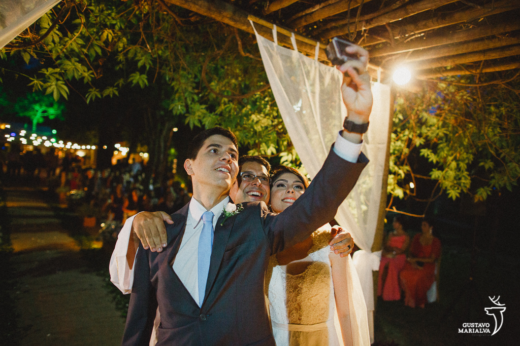 noivos tirando selfie com o padre