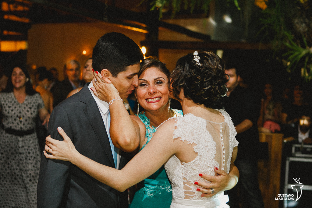 mãe da noiva emocionada recebendo abraço dos noivos