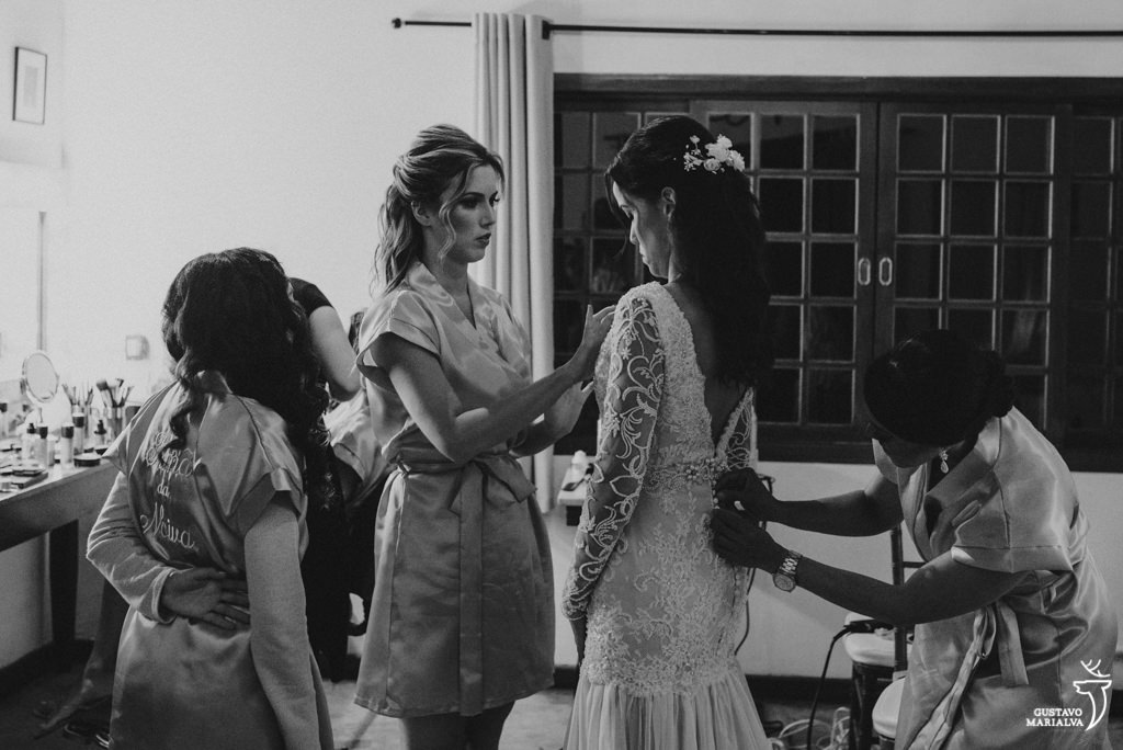 madrinha e mãe arrumando o vestido da noiva
