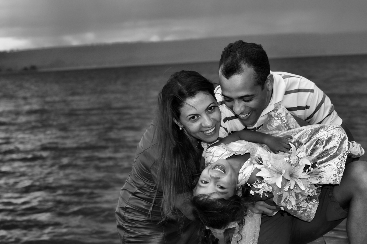a foto esta em preto e branco, mas o sorriso e colorido, com todo esse olhar da familia para o retrato o fotografo nico nao perdeu tempo em registrar essa alegria.