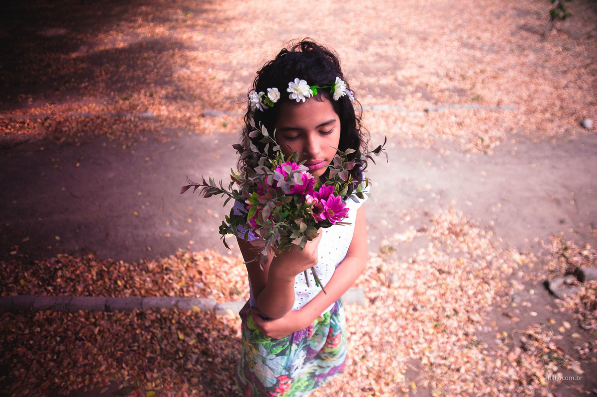 segurando as flores de olhos fechados gaby posa para o fotógrafo de ensaio infantil Joilly em Feira de Santana Bahia num lindo dia, chão de flores