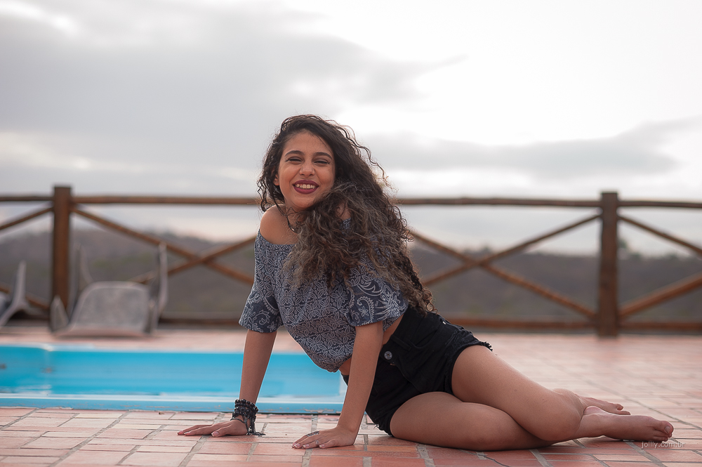isa sentada na varanda perto da piscina