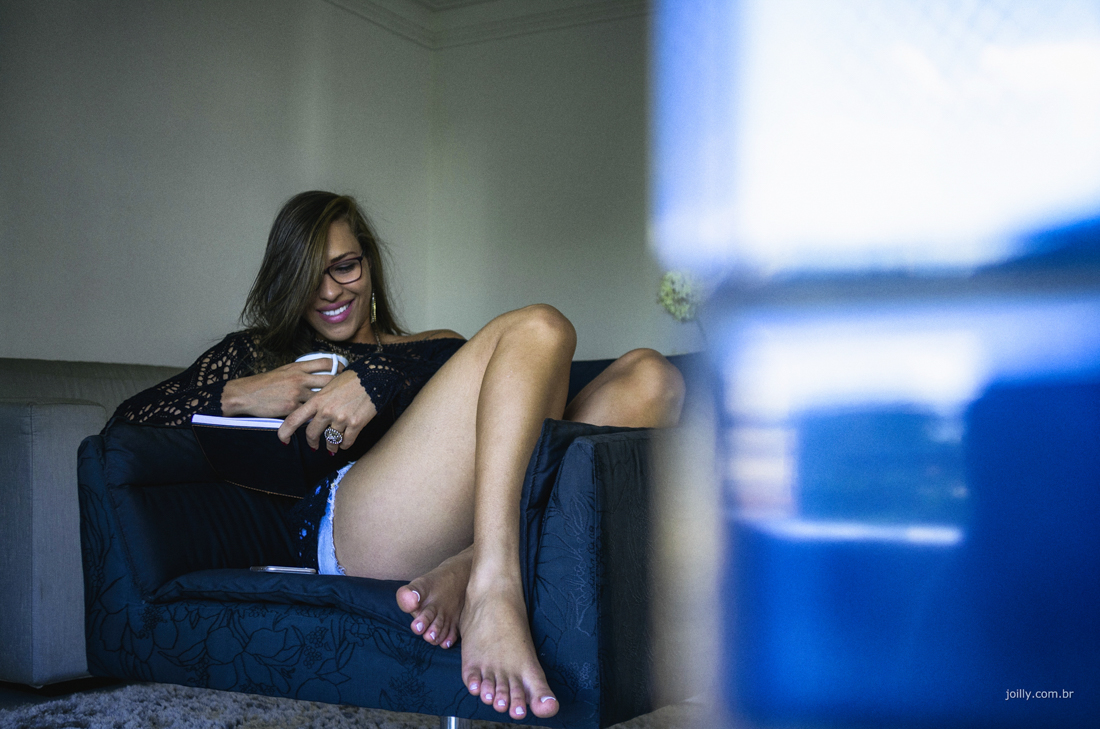 lu lendo um livro sentada no sofá