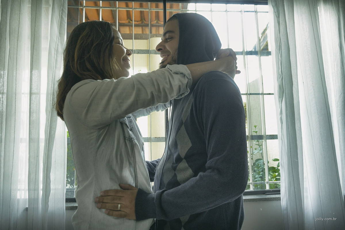 casal se abraca feliz na sala de casa
