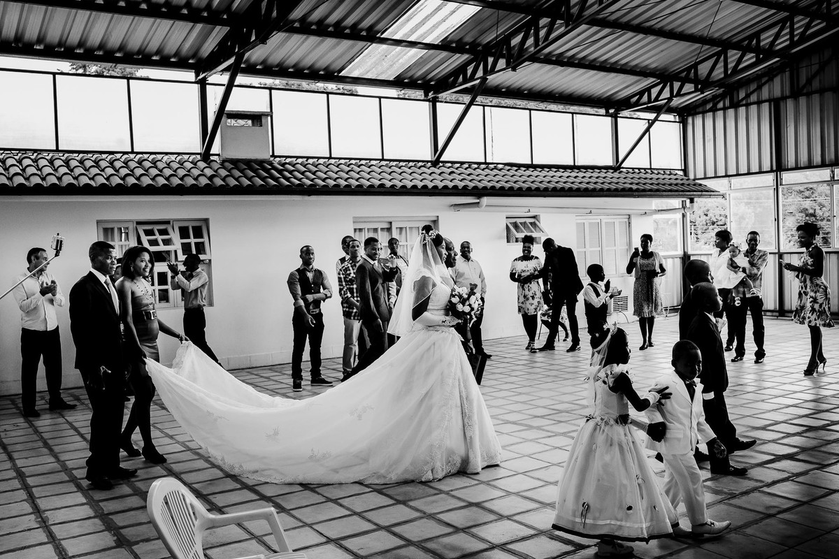 The guests cheerfully welcome the newlyweds Jack and Denise into the storehouse converted into a ballroom while the children walk in front of them