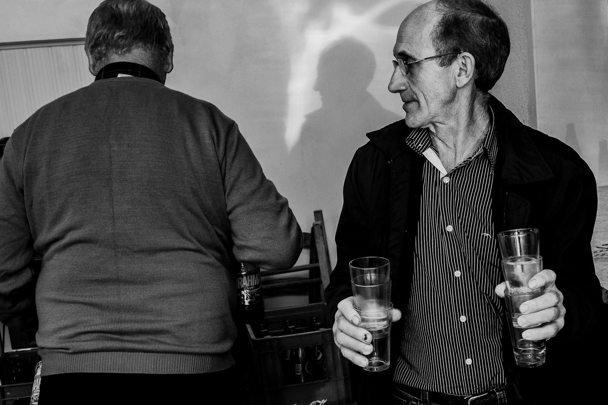 black and white photo playing with light and shadows reflection between men in the kitchen