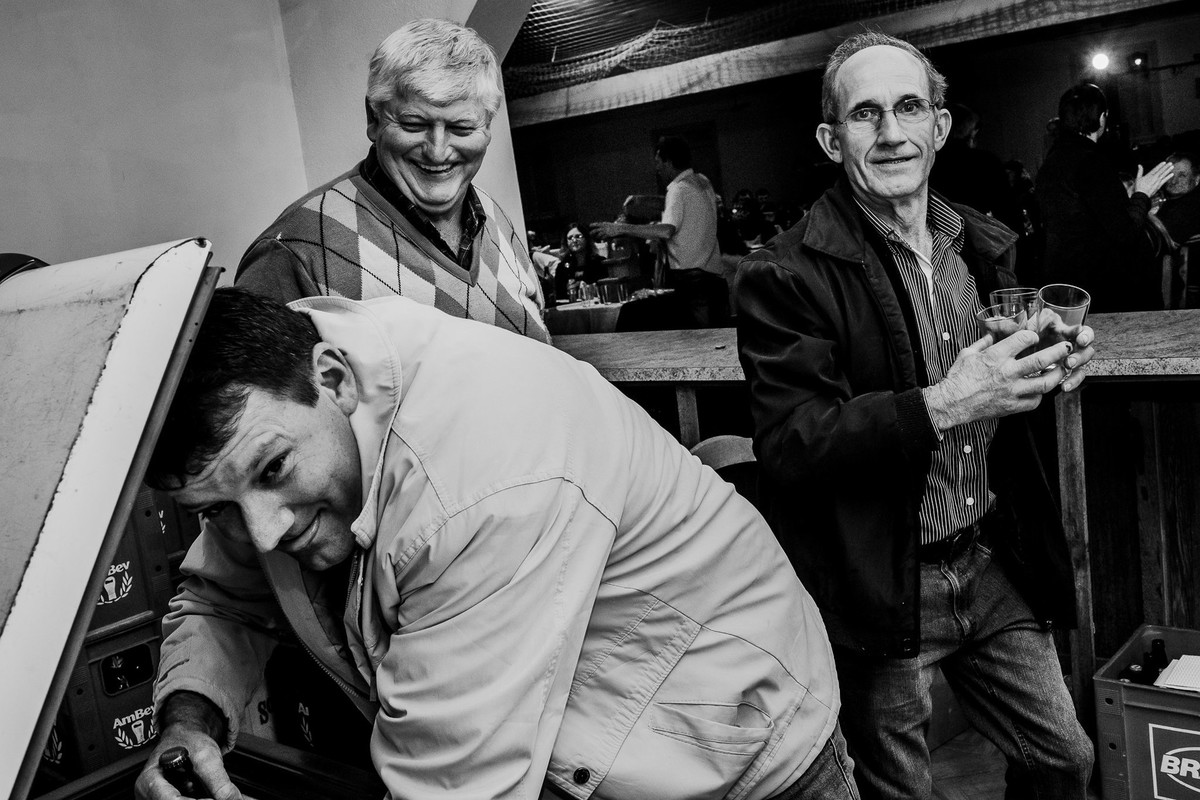 cena engraçada de homem mostrando a lingua junto a seus amigos na copa do salao de festas