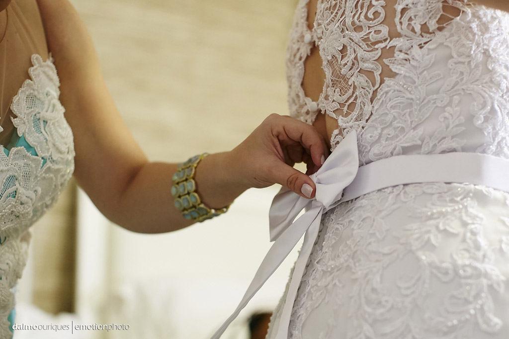 fotografo dalmo ouriques pega o detalhe do laço sendo colocando no vestido da noiva