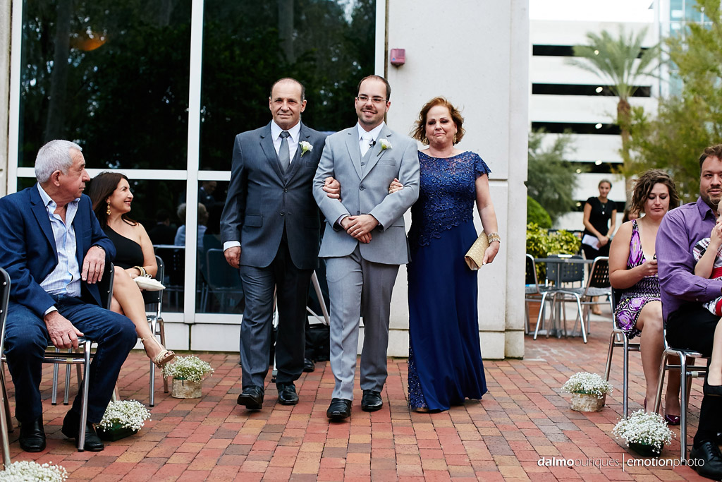 cerimonia do casamento em orlando começa com a entrada do noivo de braço com seus pais