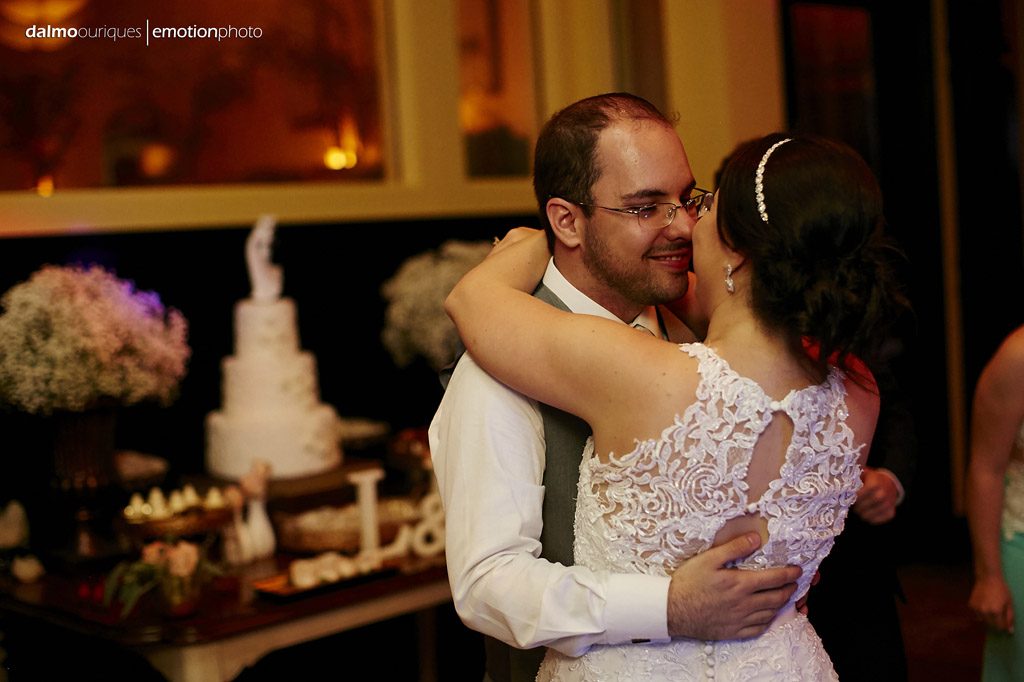 noivos curtem a festa de casamento na frente do bolo de casamento