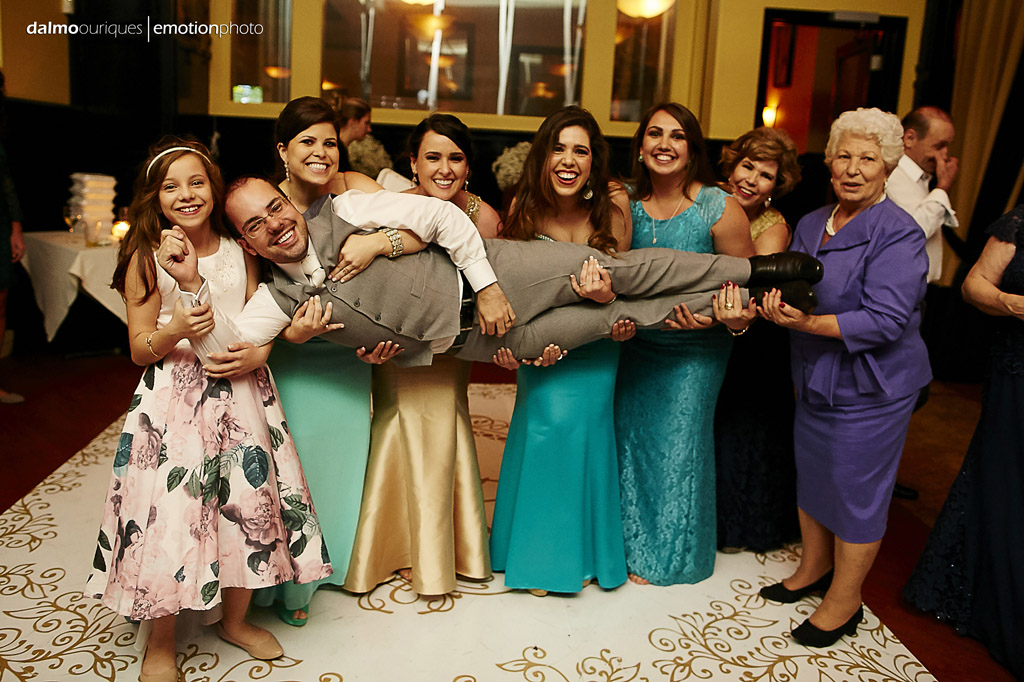 madrinhas do casamento pegam o noivo no colo, no final da festa de casamento