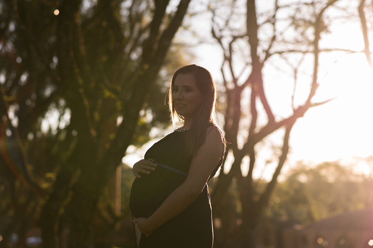 grávida gestante mamãe vestido azul cinto pérolas parque árvore dia pôr do sol luz de ouro