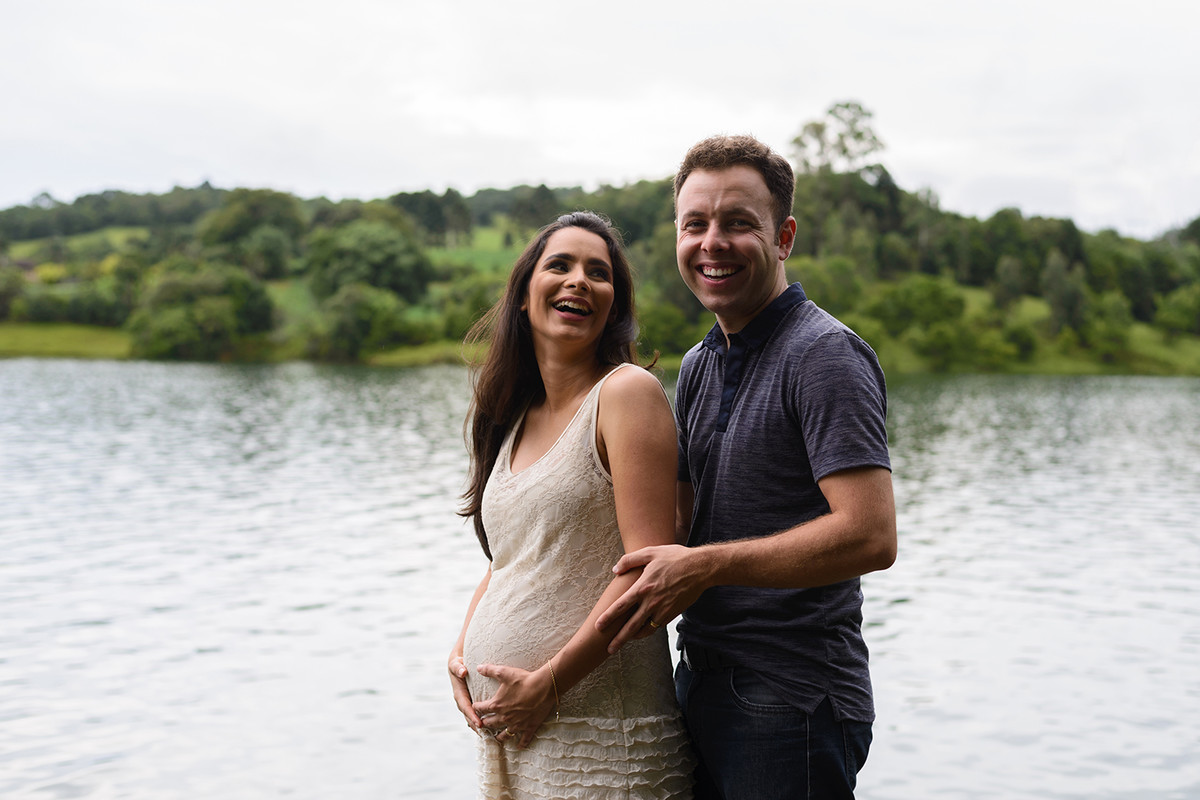 gravida gestante curitiba rio passauna passaúna com vestido de renda bege branco cabelo solto e comprido com marido esposo e natureza no fundo sorrindo