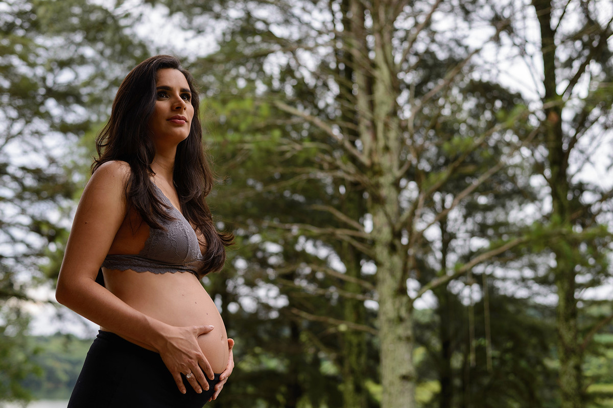 gravida gestante curitiba rio passauna passaúna com cabelo solto e comprido com natureza no fundo com sutiã cinza de renda
