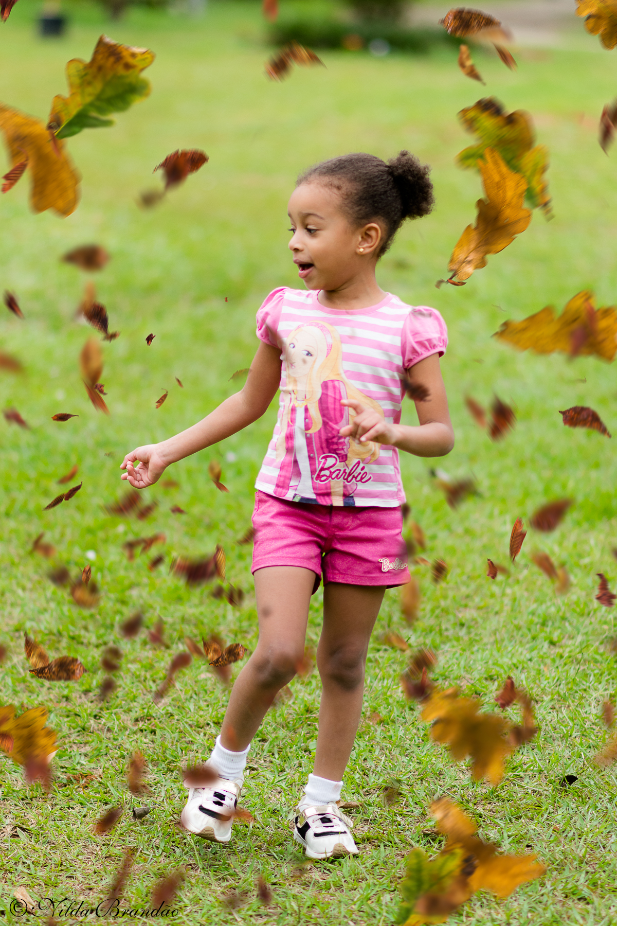 Chuva de folhas é comum no outono, a Julia se divertiu com elas no seu ensaio infantil.