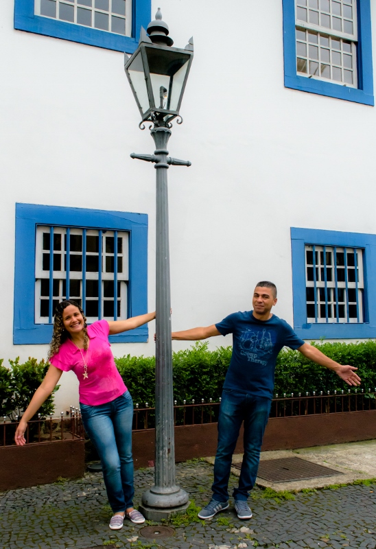 Casal se equilibrando em poste de luz no centro de são paulo
