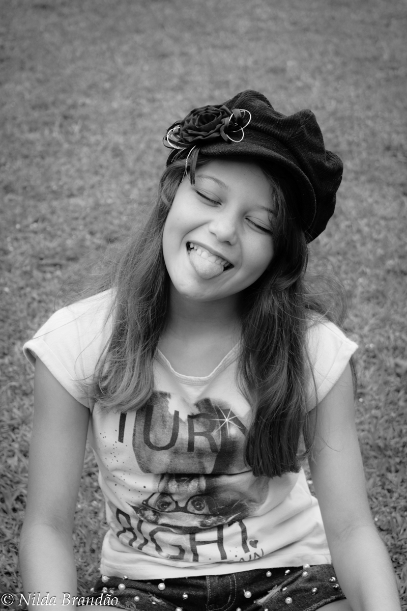 Menina mostrando a lingua em fotografia preto e branco