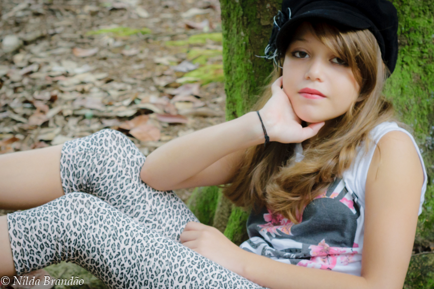 Menina sentada em tronco de árvore